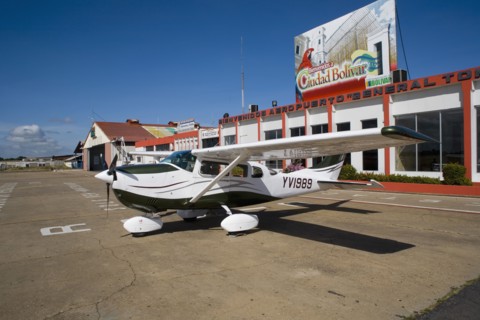 VENEZUELA, Bolivar State, Ciudad Bolivar, Airport with Cessna airplane parked outside the main
