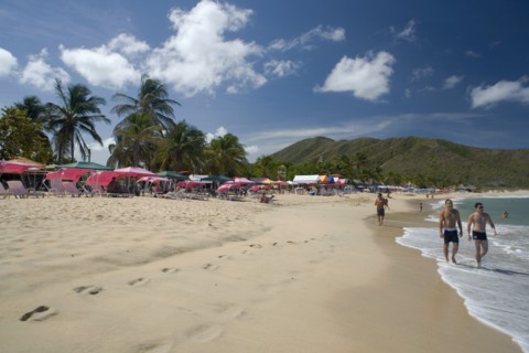 VENEZUELA, Margarita Island, Playa Caribe, View of exotic beach with people walking on the sand