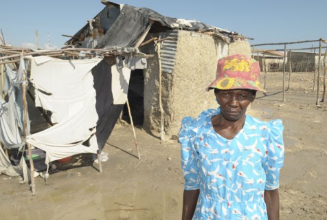 HAITI, Isla de la Laganave, woman outside her shack home.