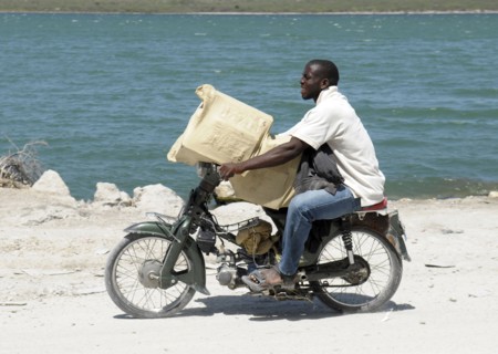 Haiti, Isla de Laganave, Man transporting goods on motorcycle.