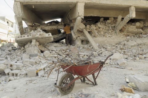 Haiti, Isla de Laganave, Building damaged by earthquake, man salvaging iron reinforcing rods from