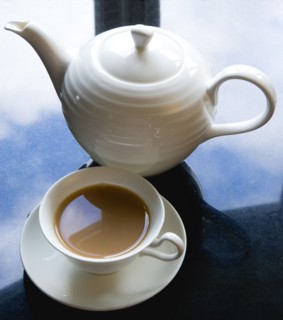 Drink, Hot, Tea, Cup of tea in a cup and saucer beside a teapot on a black granite kitchen worktop