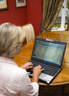 Industry, Computers, Laptop, Woman sitting at dining room table at home checking her email account