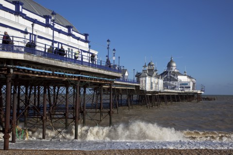 England, East Sussex, Eastbourne pier and pebble beach.