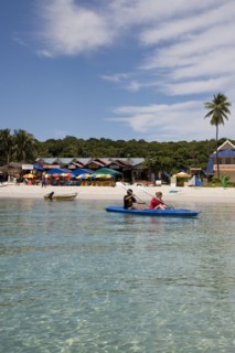 Malaysia, Pulau Perhentian Kecil, Terrengganu coast with two people canoeing close to beach.