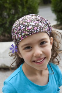 Greece, Macedonia, Thessaloniki, Head and shoulders portrait of a young smiling girl with a purple