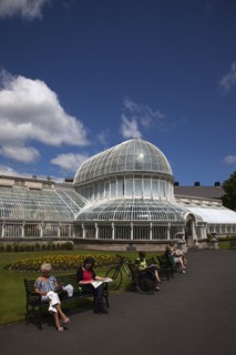 Ireland, Northern, Belfast, Botanic Gardens with people sat on benches outside the Palm House next