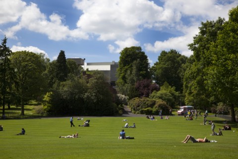Ireland, North, Belfast, Botanic Gardens with people relaxing in the sun.
