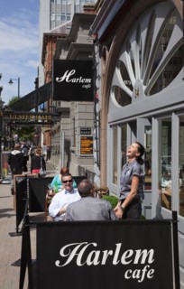 Ireland, North, Belfast, Bedford street, waitress enjoying a joke with customers outside Harlem