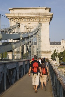 Budapest, Pest County, Hungary. Tourists with matching day packs crossing Szechenyi Chain Bridge or