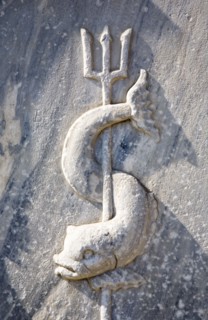 Athens, Attica, Greece. Close cropped view of stone carving of sea creature curved around trident.