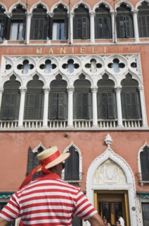 Venice, Veneto, Italy. Cropped shot of gondolier wearing red and white striped shirt and straw