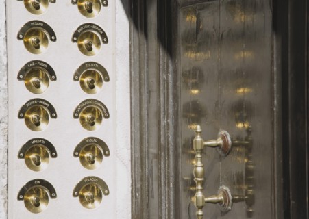 Venice, Veneto, Italy. Brass doorbells with nameplates on restored facade of apartment building