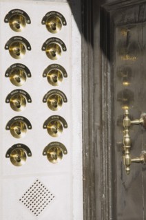 Venice, Veneto, Italy. Brass doorbells with nameplates on restored facade of apartment building