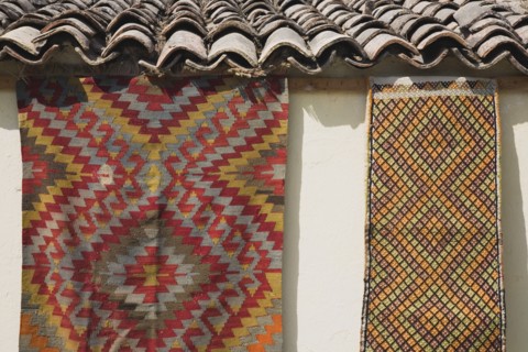 Selcuk, Izmir Province, Turkey. Kilims hanging up to dry in sunshine on walls of village house.
