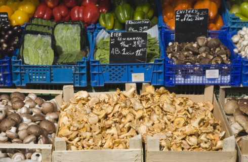 Vienna, Austria. Market stall with display including mushrooms peppers mange-tout and aubergines.