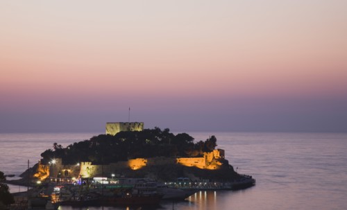 Kusadasi, Aydin Province, Turkey. Sunset over Guvercin Ada the peninsula of Kusadasi also known as