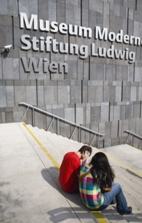 Vienna, Austria. Neubau District. Young student couple sitting on the steps of the Museum of Modern