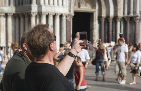 Venice, Veneto, Italy. Centro Storico St. Marks Square Tourist takes photograph on mobile phone