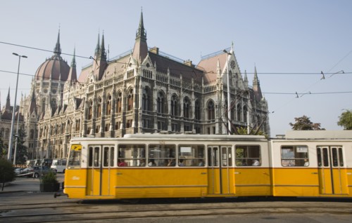 Budapest, Pest County, Hungary. Yellow tram passing the Parliament Building. Hungary Hungarian