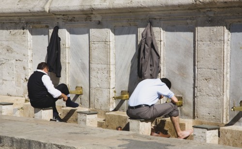 Istanbul, Turkey. Sultanahmet. The New Mosque or Yeni Camii. Two men washing and making ablutions