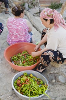 Sirince, Aydin Province, Turkey. Women preparing red and green chilies outside in late afternoon