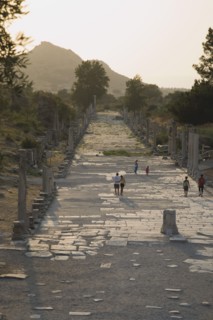 Selcuk, Izmir Province, Turkey. Ephesus. Tourists on paved road lined by broken columns in late