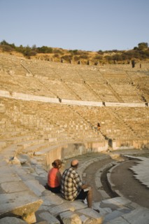 Selcuk, Izmir Province, Turkey. Ephesus. Tourist couple sitting in amphitheatre in the antique city