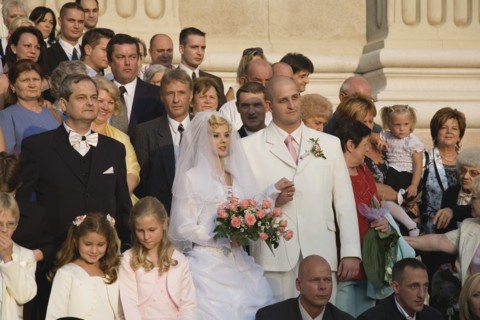 Budapest, Pest County, Hungary. Bride and groom with wedding guests pose for photographs on steps