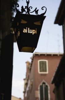Venice, Veneto, Italy. Centro Storico Lantern outside restaurant inscribed with ai lupi which