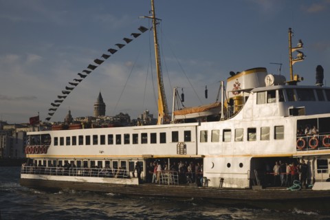 Istanbul, Turkey. Sultanahmet. Crowded ferry flying Turkish flag on the Bosphorous with city behind