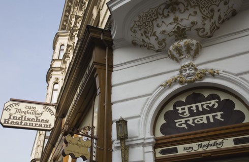 Vienna, Austria. Neubau District. Indian Restaurant white and gold painted facade and hanging sign.
