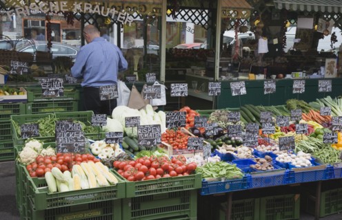 Vienna, Austria. The Naschmarkt. Stallholder standing behind and with back to display of fresh