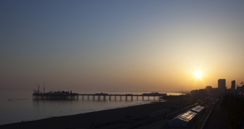 Brighton, East Sussex, England. View of the pier at sunset from the seafront promenade in Kemptown.