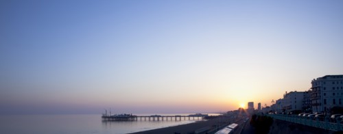 Brighton, East Sussex, England. View of the pier at sunset from the seafront promenade in Kemptown.