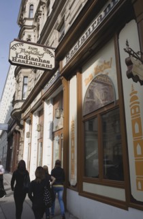 Vienna, Austria. Neubau District. Pedestrians passing Indian restaurant with painted facade and