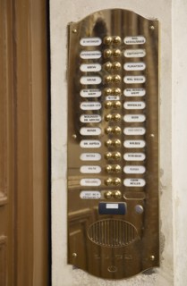 Vienna, Austria. Polished brass bell and names of residents at entrance to apartment. Austria