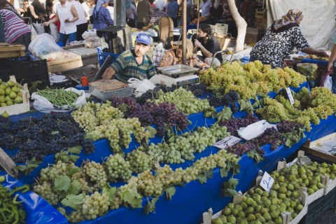 Kusadasi, Aydin Province, Turkey. Stall with display of grapes figs beans and chilies for sale in