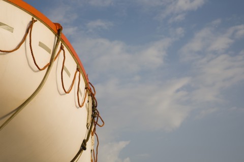 Samos, Northern Aegean, Greece. Part view of lifeboat against summer sky on ferry between Samos and