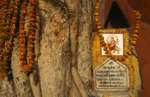 Varanasi, Uttar Pradesh, India. Detail of roadside Hindu Shrine adorned with flower garlands. Asia