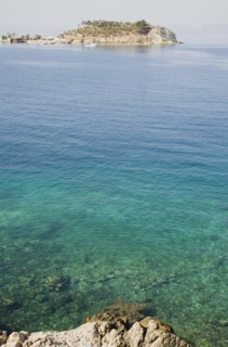 Kusadasi, Aydin Province, Turkey. View towards Guvercin Ada or Pigeon Island across clear turquoise