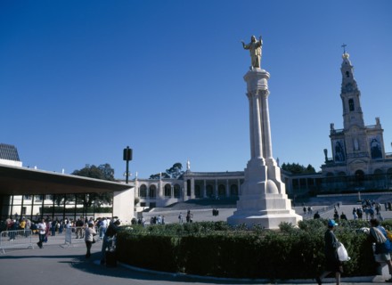 Fatima, Beira Litoral, Portugal. Golden Statue of Christ with church in background Portuguese