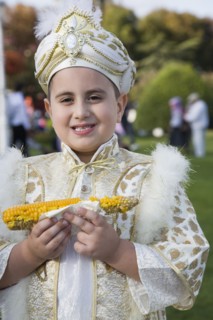 Istanbul, Turkey. Sultanahmet. Young boy eating sweetcorn cooked on the cob wearing traditional