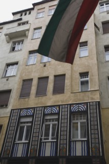 Budapest, Pest County, Hungary. Part view of Art Nouveau facade with flag in top foreground.