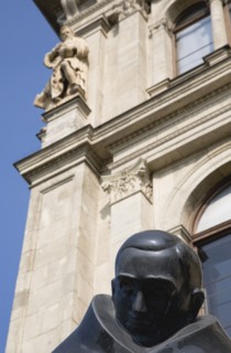 Budapest, Pest County, Hungary. Detail of bronze statue in front of art nouveau building facade.