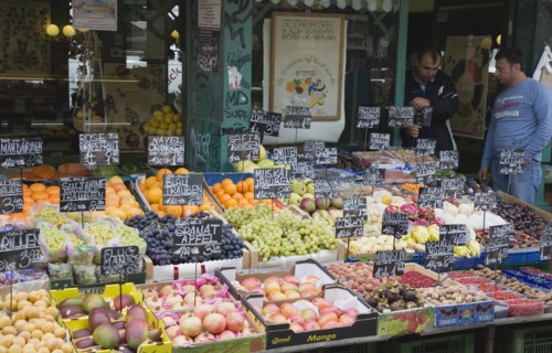 Vienna, Austria. The Naschmarkt. Owners of market fruit stall standing behind shopfront display