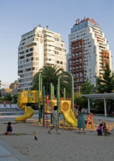 Santiago, Chile. Children playing in the sand while their mothers watch at a playground in Plaza
