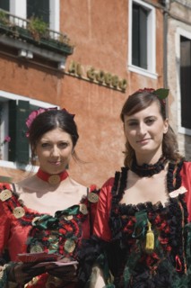 Venice, Veneto, Italy. Portrait of two young women wearing traditional costume to promote Venice