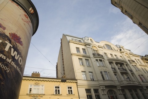 Vienna, Austria. Part view of building exterior facades with advertising column in foreground.