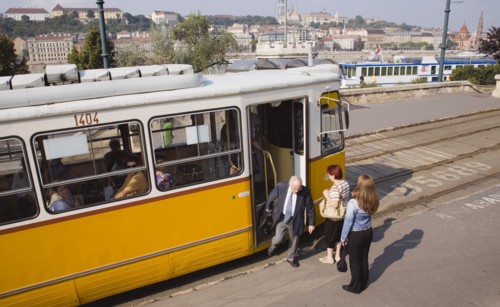 Budapest, Pest County, Hungary. Tram with passengers alighting and view towards the River Danube